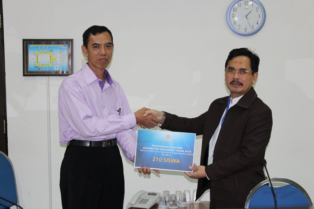 DIREKTUR Kemahasiswaan UNAIR Dr. M. Hadi Subhan, SH., MH., CN., (kanan) menyerahkan beasiswa kepada perwakilan sekolah dasar (SD) di lingkungan kampu Unversitas Airlangga, Senin (21/5). (Foto: Feri Fenoria Rifai)